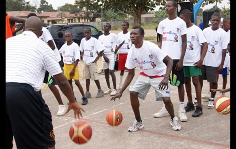 Former NBA Player Bo Outlaw dribbles with a teenager from Congo Brazzaville.