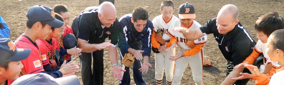 Cal Ripken huddles with young baseball players. 