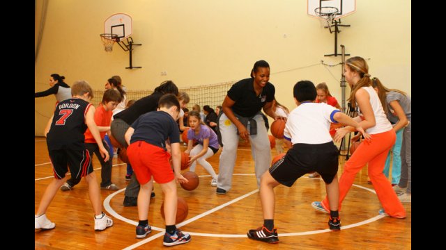 Young Ukrainian athletes learn new dribbling techniques during a fun basketball activity with Tamika Raymond.