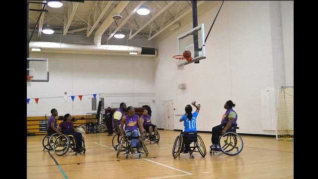 The group participates in a wheelchair basketball game during a session in Washington, D.C. 