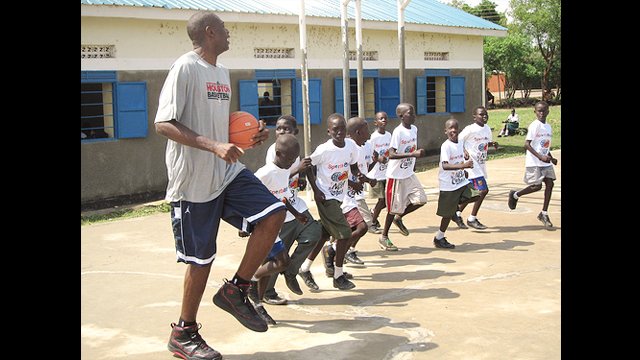 The boys try to keep up with the NBA star Dikembe Mutombo during practice.