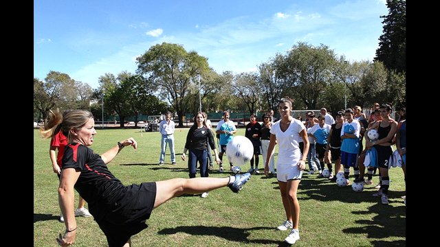 Former U.S. Women's National Team star Amanda Cromwell demonstrates a kick for the young players in Argentina.