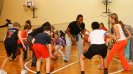 Young Ukrainian athletes learn new dribbling techniques during a fun basketball activity with Tamika Raymond.