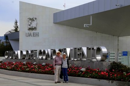 Man and woman stand in front of a building sign