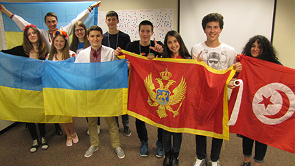 Dina (third from right) poses with the flag of Montenegro during an activity at her host school.