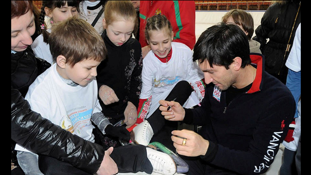 Evan Lysacek signs ice skates for young fans.