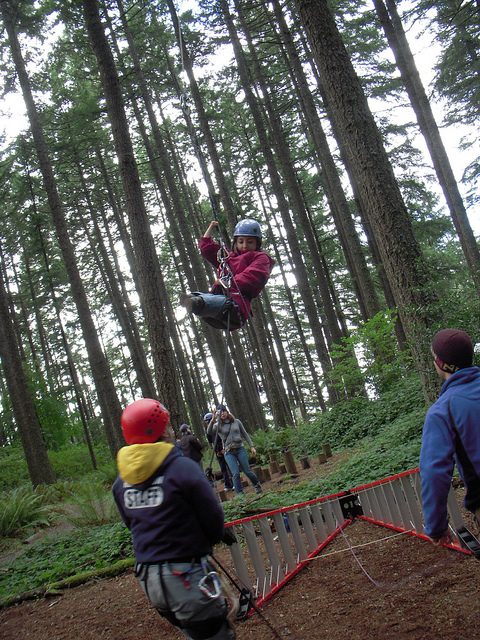 Azima on a ropes course with Mobility International USA in Eugene, OR