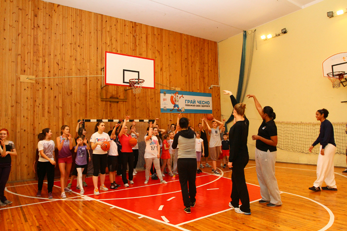 Sports Envoys Tamika Raymond and Nykesha Sales work with NBA representative Becky Bonner to lead an exercise focused exclusively on three-pointers.