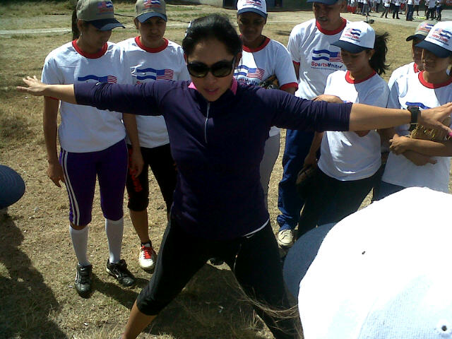 Ruby Rojas demonstrates warm-up techniques to a group of Nicaraguan softball players.