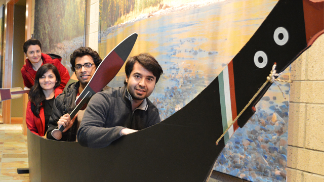Several young people in a display boat in what looks like a museum