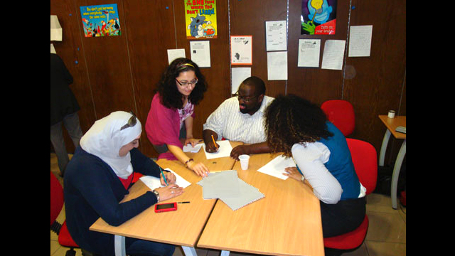 Syrian teachers work together on a project during a teacher training workshop.