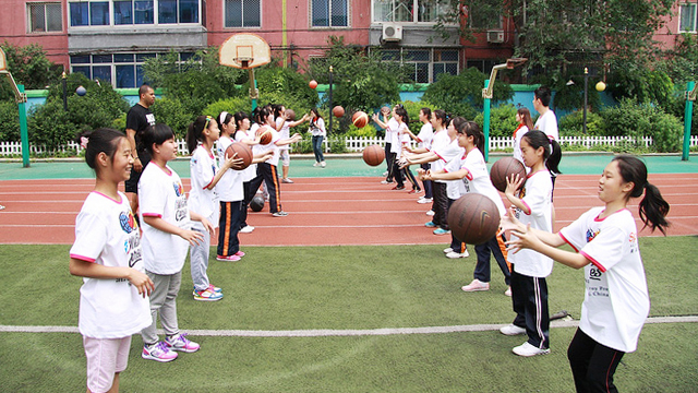 Tamika Raymond’s husband, Ben Raymond, teaches passing drills to girls from the Shenhe Migrant Workers Elementary School in China.