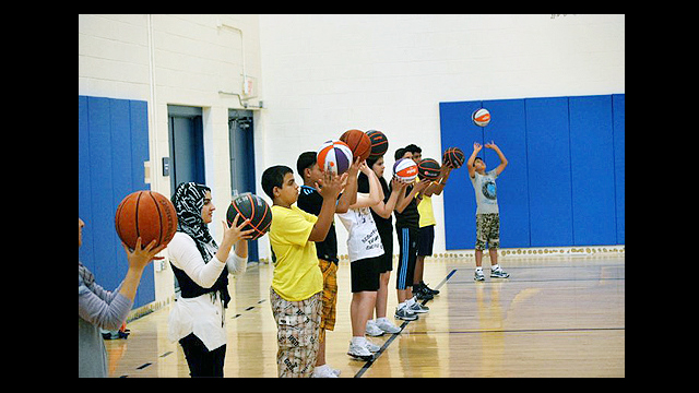 The participants practice ball skills with Brett Issacson of One-on-One Basketball.