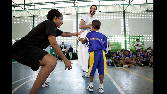 Nykesha Sales and Greivis Vasquez encourage a young clinic participant to come to the center court.