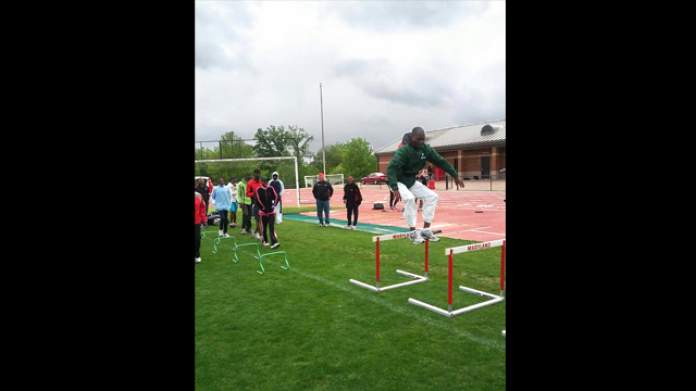 The participants practice different track and field events including shot put and hurdles.