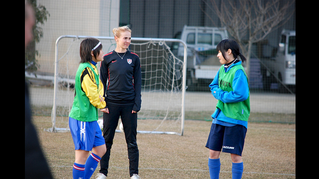 U.S. defender Heather Mitts discusses strategy techniques with her young Japanese teammates.