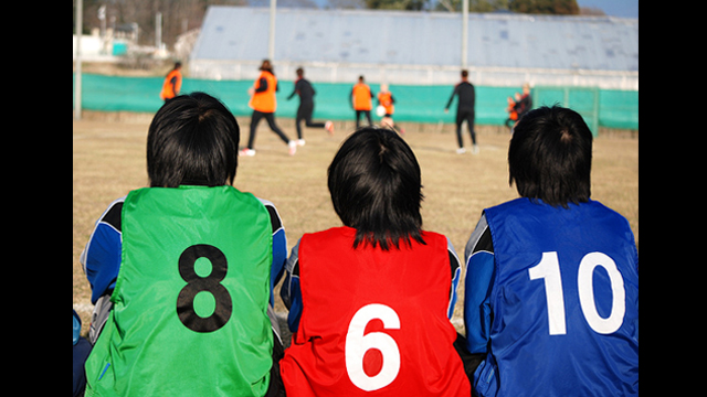 Supportive team mates watch their peers play with the U.S. Women’s National Team.