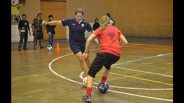 Shannon MacMillan and Tracy Noonan demonstrate a drill for a group of high school soccer players in Solala, Guatemala.