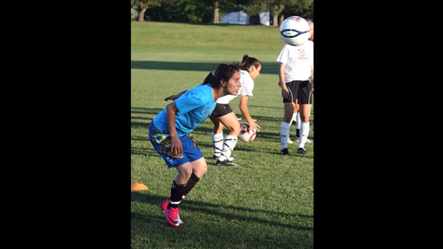 Fatima, from Pakistan, heads the ball