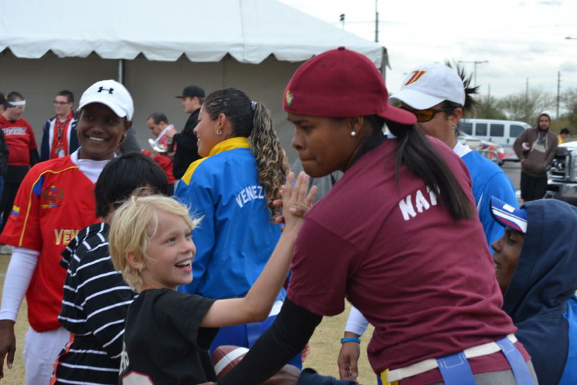 The young coach visitor high-fives a young American emerging athlete. 
