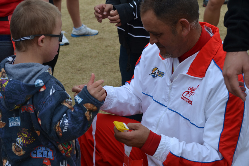 A coach visitor attaches a flag to a young American emerging athlete at a cross-training flag-football session. 