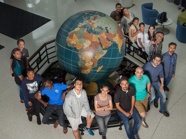 International students pose around a large globe statue