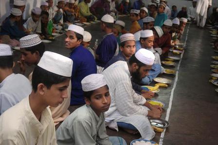 Young men gather in a madrassa for the evening meal called Iftar to break their fast durning the month of Ramadan. Kala Chandpur, Dhaka