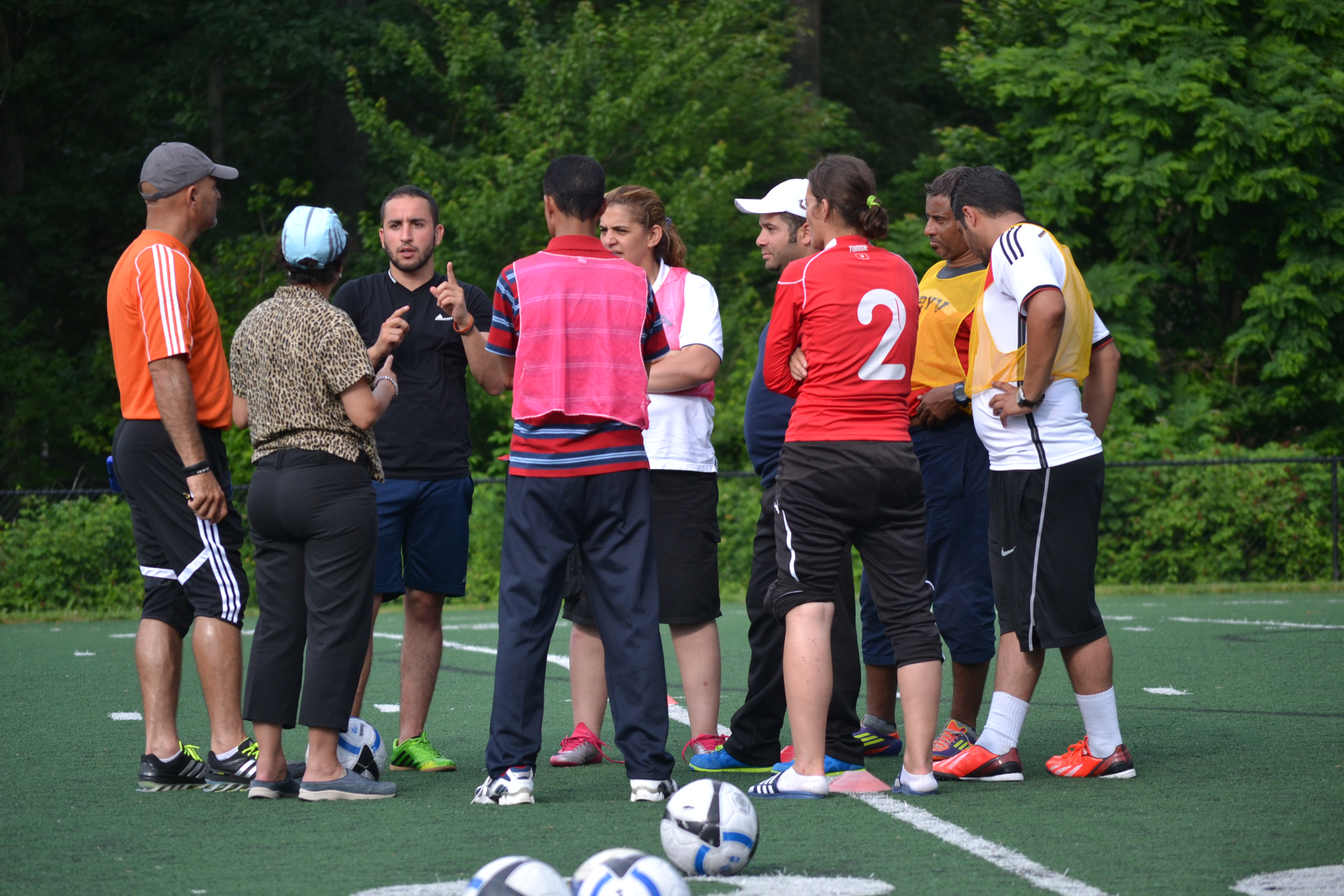 The coaches come together to get an explanation of new drills and conditioning methods they could implement with their athletes back home.