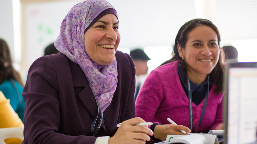 Photo of Teaching Excellence and Achievement (TEA) participants Taghreed Mubaideen, a Jordanian high school teacher and Suzy Huiracocha Panama, an Ecuadorian high school teacher, chat with classmates at Winthrop University