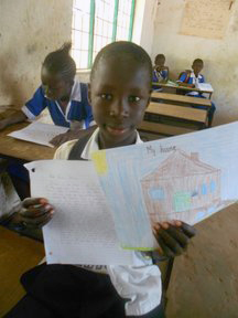 Young boy holds up letter and drawing of a house