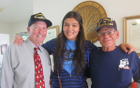 Gulnar posing with veterans she visits at their nursing home