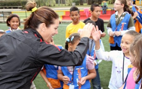 Julie Foudy provides positive encouragement to a girl for scoring a goal.