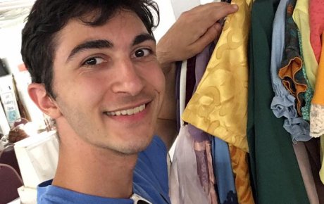 Man touching clothes on a wardrobe rack