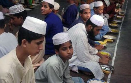 Young men gather in a madrassa for the evening meal called Iftar to break their fast durning the month of Ramadan. Kala Chandpur, Dhaka