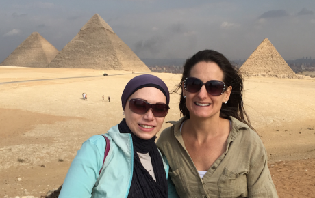 Two women pose in front of Egyptian pyramids