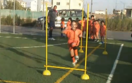 Cypriot children run drills to improve strength and agility during soccer practice