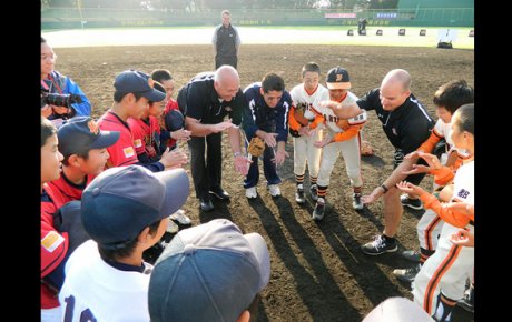 Cal Ripken huddles with young baseball players. 