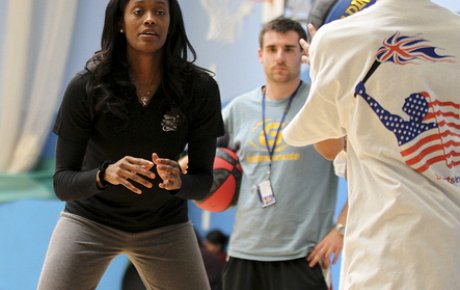 Swin Cash shares her skills through drills with a young player from England.
