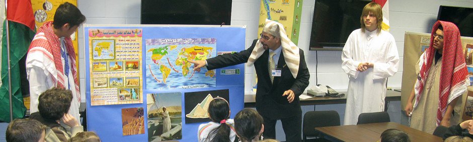 Photo of teacher in front of student pointing to a presentation board