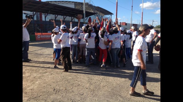 After an invigorating game, Nicaraguan players celebrate the sport of softball with a group cheer.