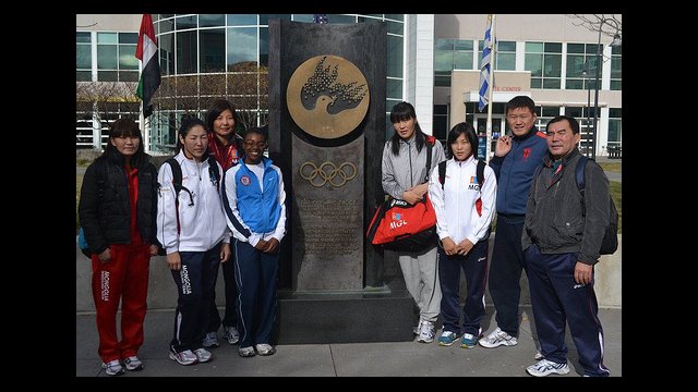 Mongolian wrestlers pose at the Olympic Truce statue in Colorado.