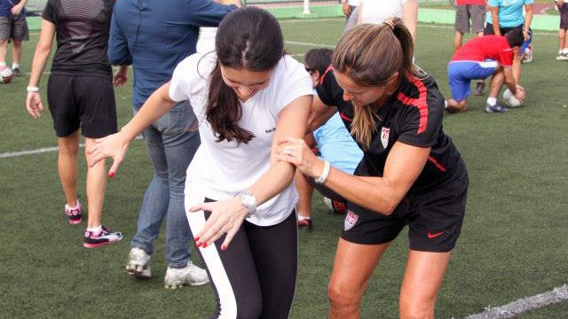 Young female athletes work to perfect the skills and drills that they learned from Julie Foudy during a soccer session. 