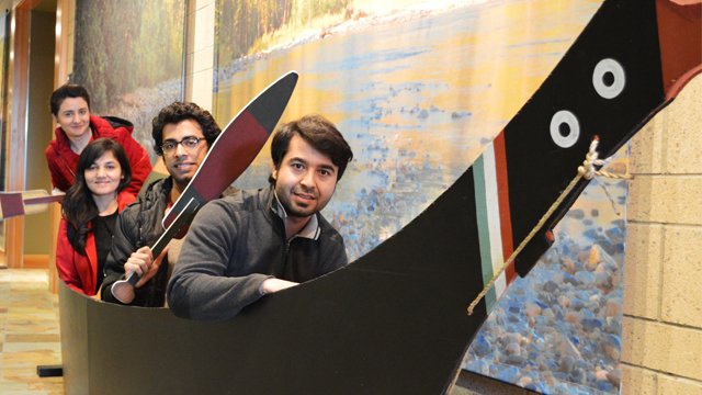 Several young people in a display boat in what looks like a museum
