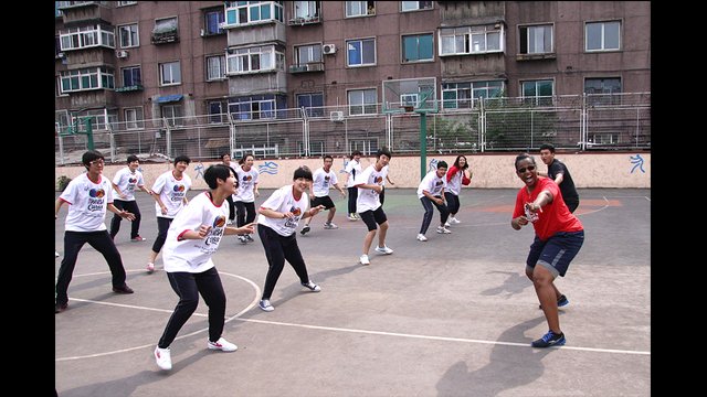 Tamika Raymond practices defensive sliding skills with the girls from Anshan No. 3 High School in China.