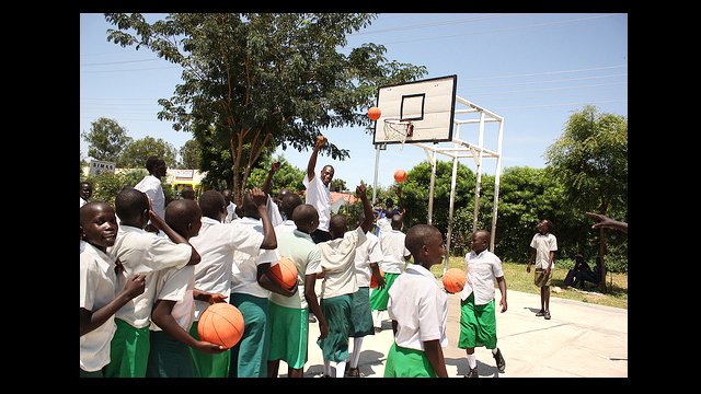 Dikembe Mutombo directs the girls to line up and shoot.