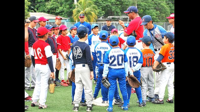 Young players cluster to hear Barry Larkin’s baseball tips in Guayaquil, Ecuador.