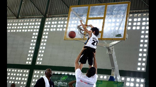 A young Venezuelan boy slam dunks with the help of Greivis Vasquez.