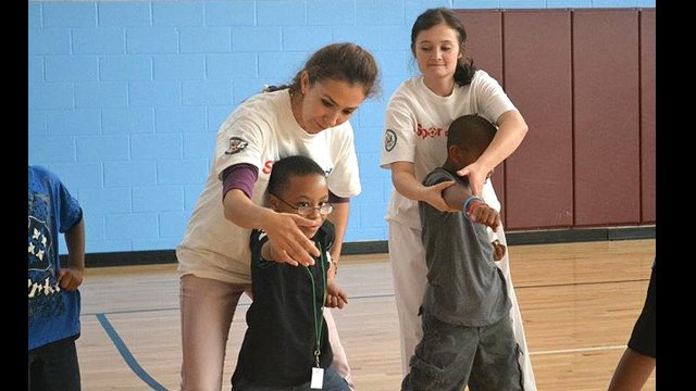 The coaches practice what they learned in a youth sports development session with kids from a local Boys and Girls club