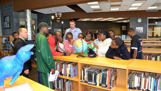 The group points out their home countries on the globe during their visit to a local high-school in Maryland.