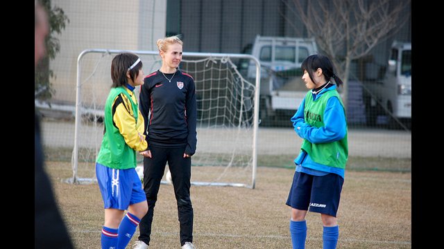 U.S. defender Heather Mitts discusses strategy techniques with her young Japanese teammates.
